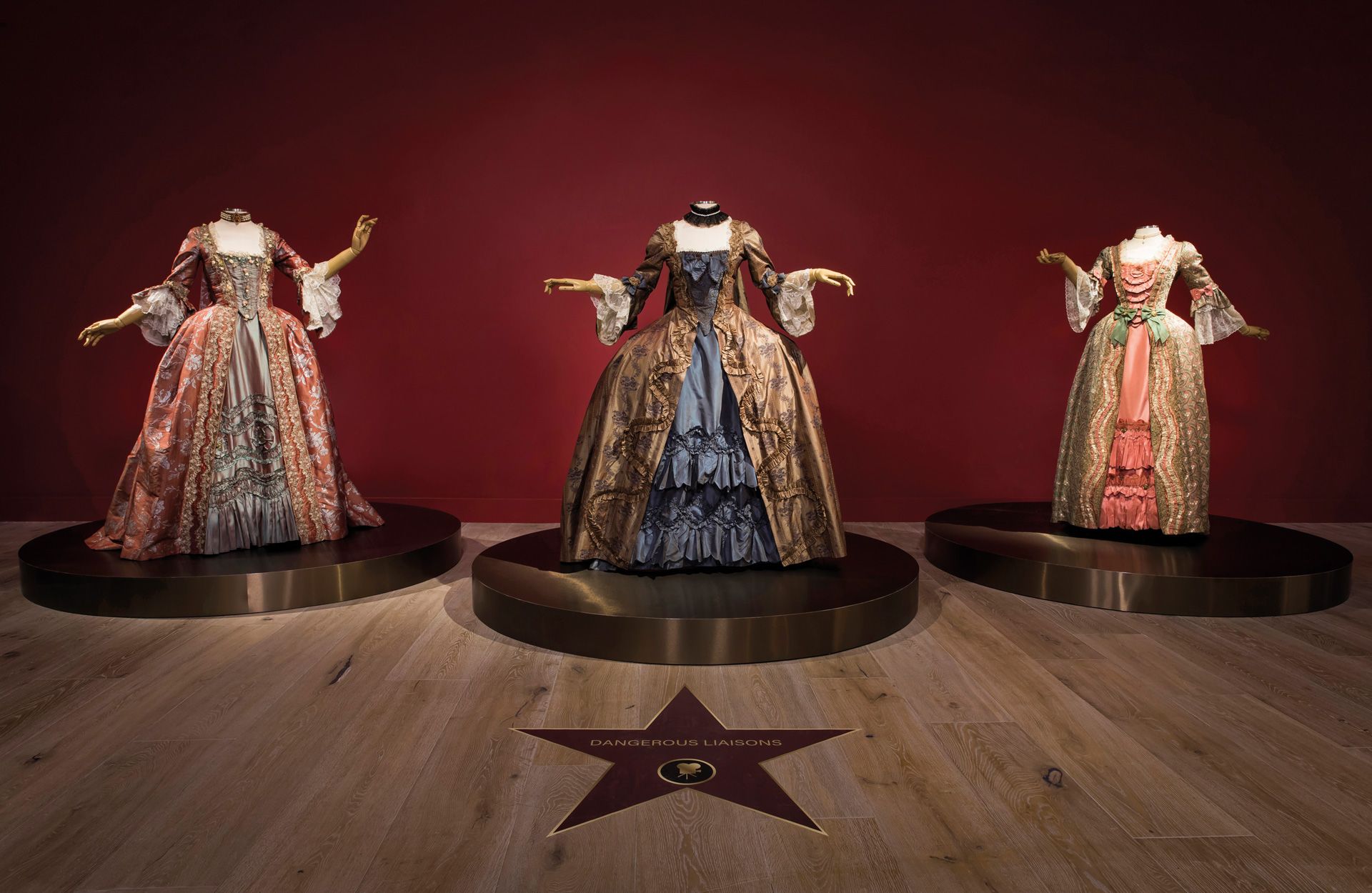 Image by Cospop costume hire showing three Victorian era dresses displayed in an exhibition