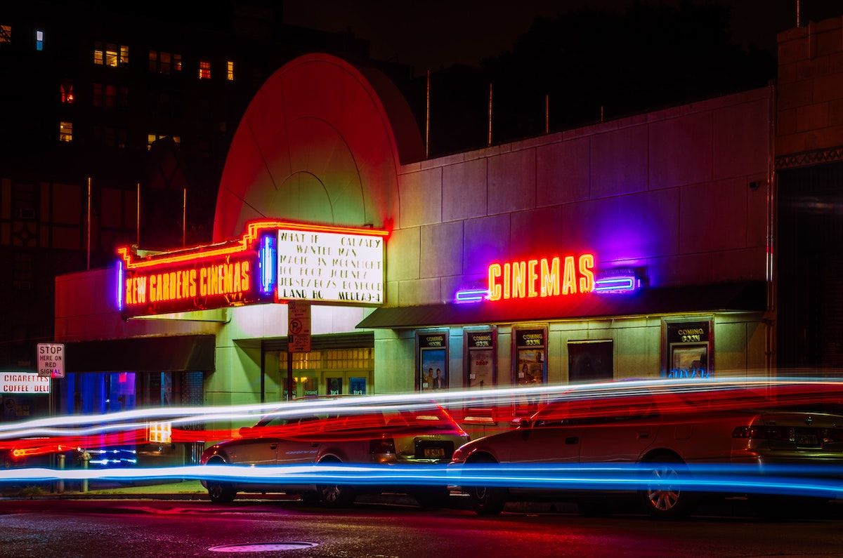 image of a cinema at night with neon signage 