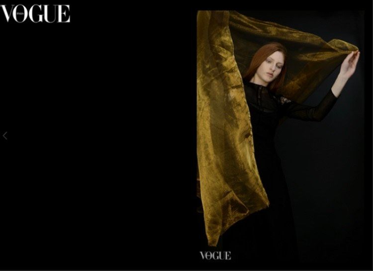 Vogue shoot of a woman holding up a yellow scarf by fashion photographer Zuzana Breznanikova 