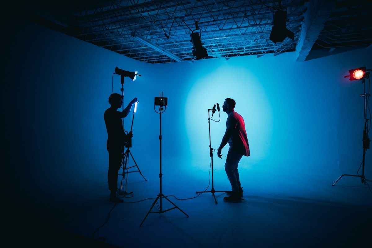 image of a man being filmed performing in a studio with blue light